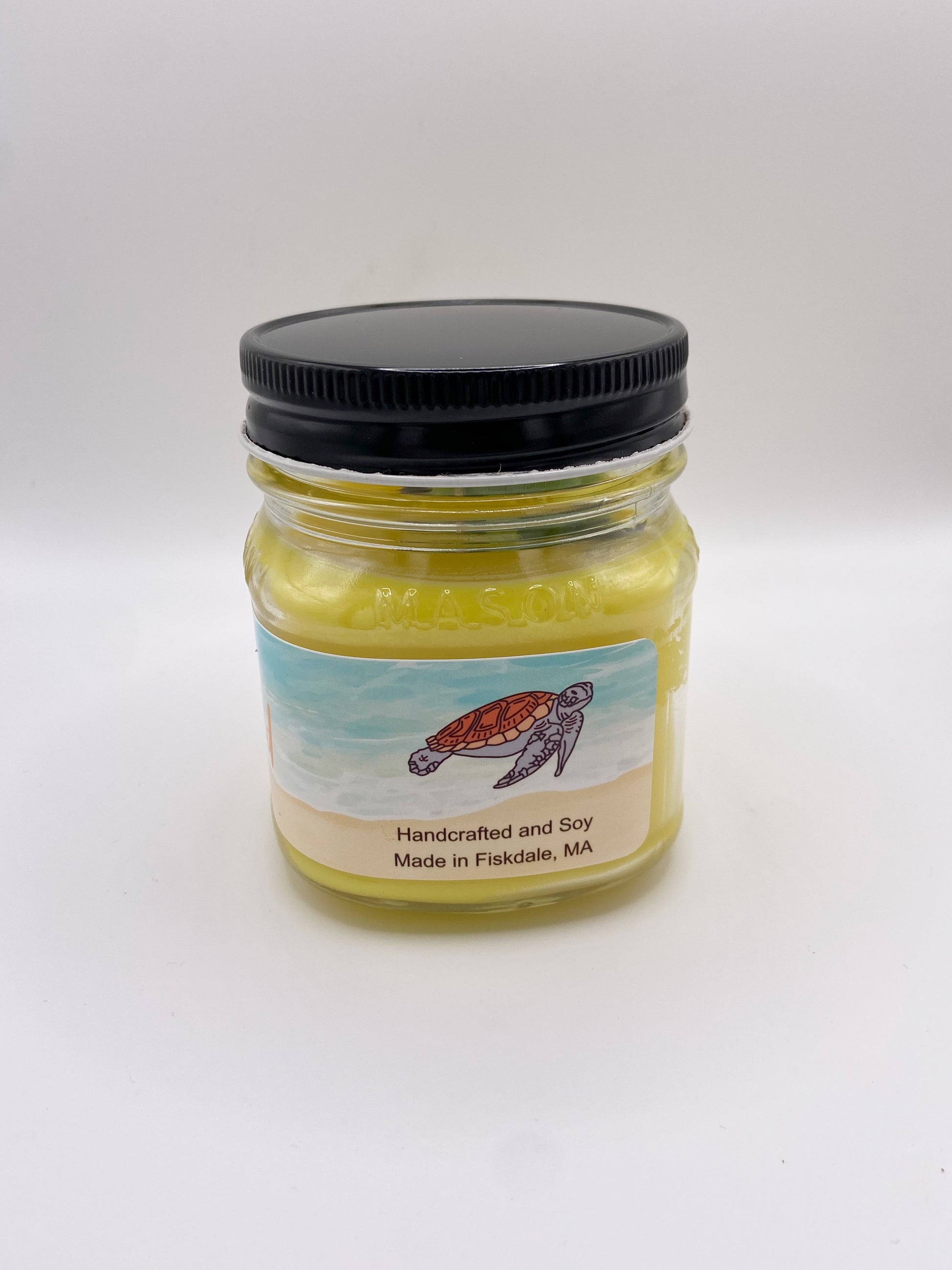 Jar of candle with a turtle label on a white background