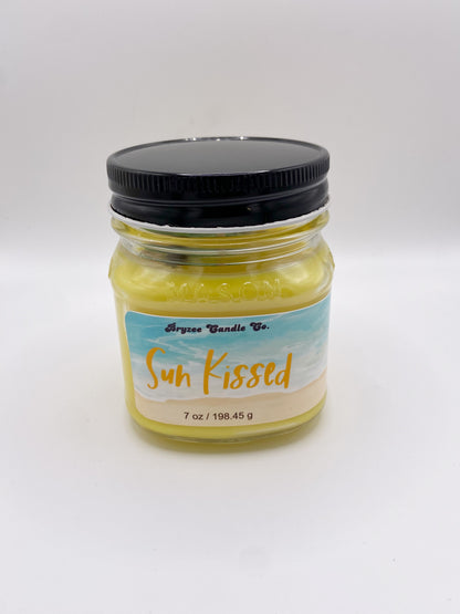 Jar of 'Sun Kissed' candle with a black lid on a white background